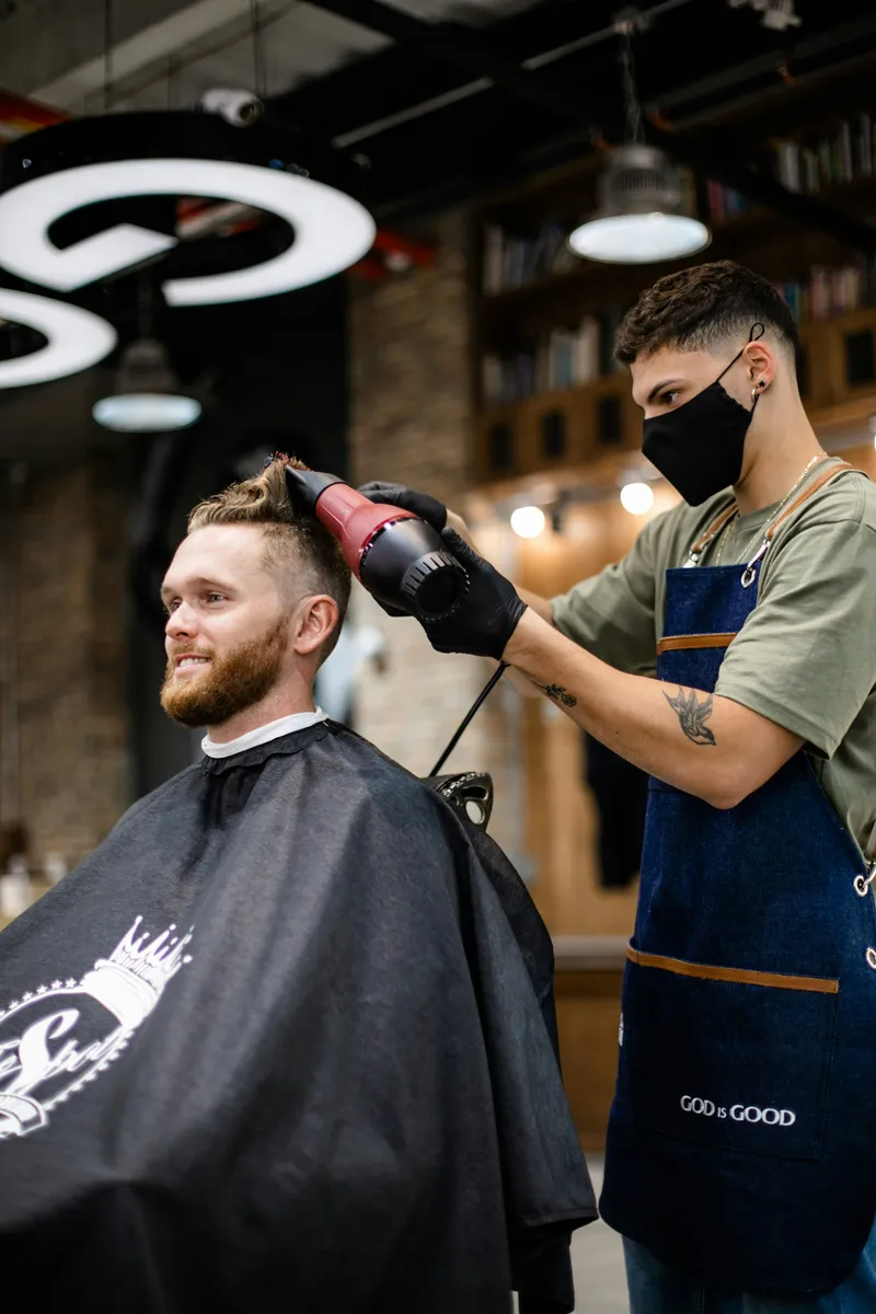 Modern bir kuaför salonunda müşterisinin saçını şekillendiren kuaför
